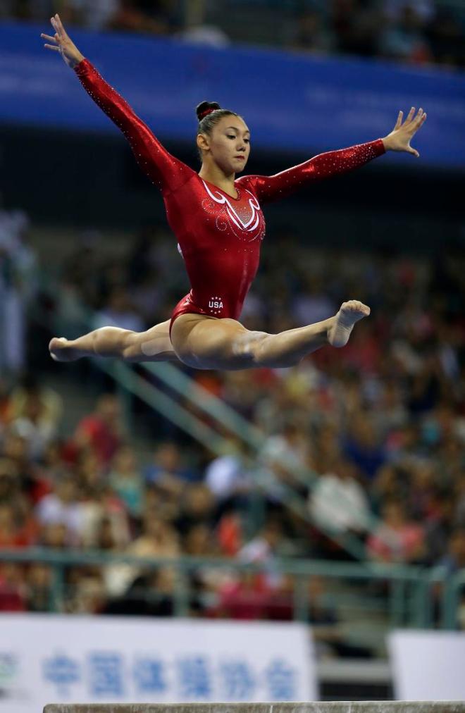 Kyla Ross of the United States jumps from the balance beam as she competes in the women's team final of the Artistic Gymnastics World Championship at the Guangxi Gymnasium in Nanning, capital of southwest China's Guangxi Zhuang Autonomous Region Wednesday, Oct. 8, 2014. (AP Photo/Andy Wong)
